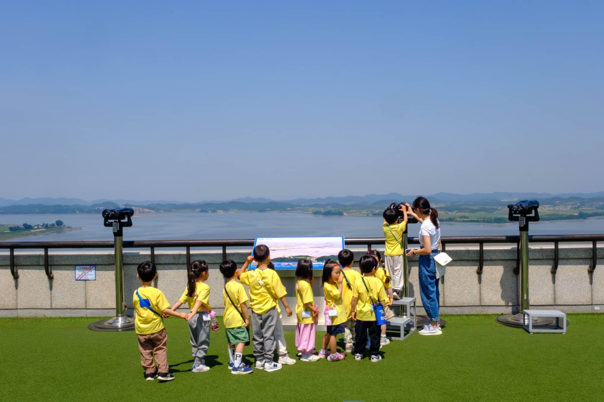 Kindergarten children on a field trip wait in line to watch North Korea through a telescope at Odusan Observatory.