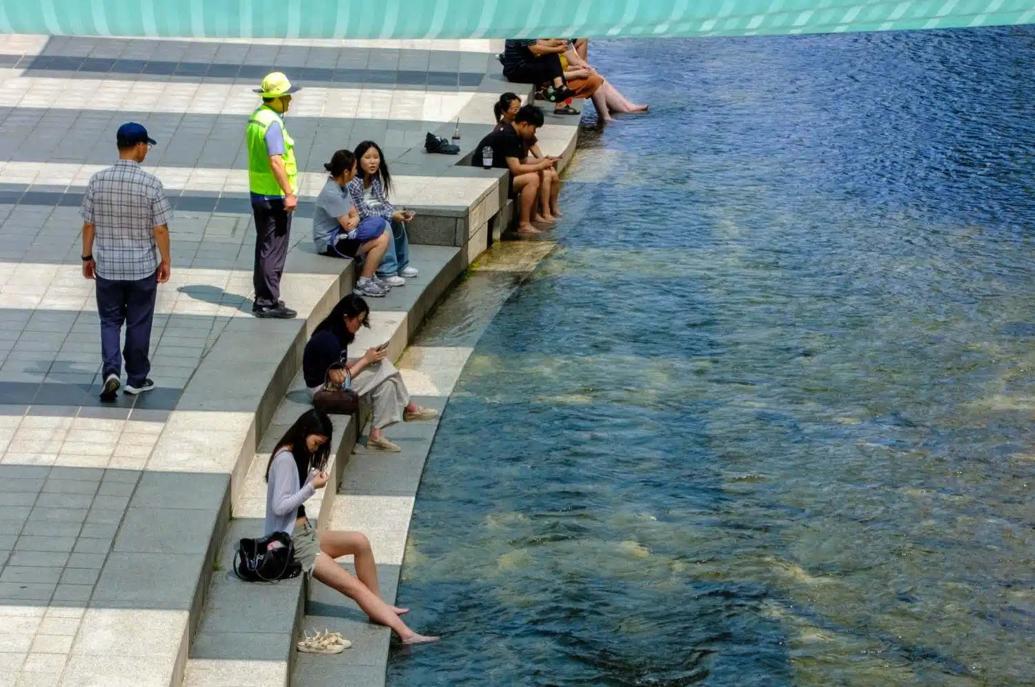 cheonggyecheon-series-seoul-1 People relax with their feet in the water along Cheonggyecheon stream in central Seoul