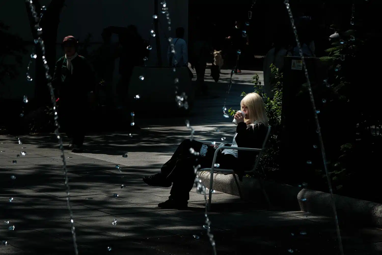 gwanghwamun-fountains-blond-woman A woman with blond hair drinks a coffee near the fountains on Seoul's Gwanghwamun square in summer.