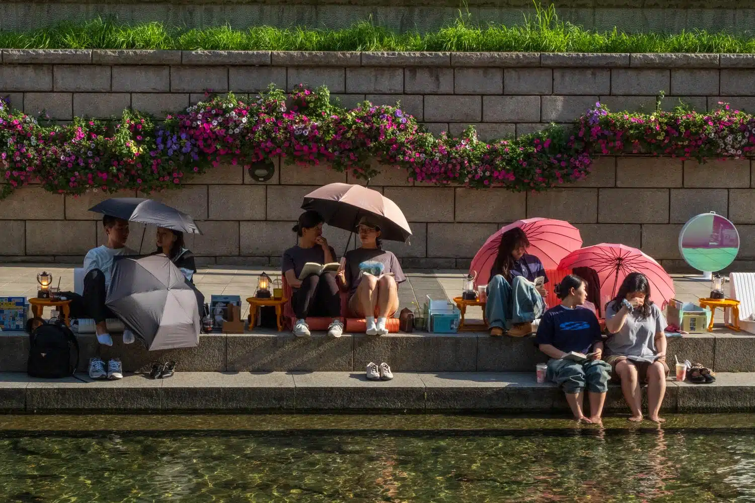 seoul-outdoor-library-summer-2026-20 People chill along Cheonggyecheon stream in central Seoul by a warm May day