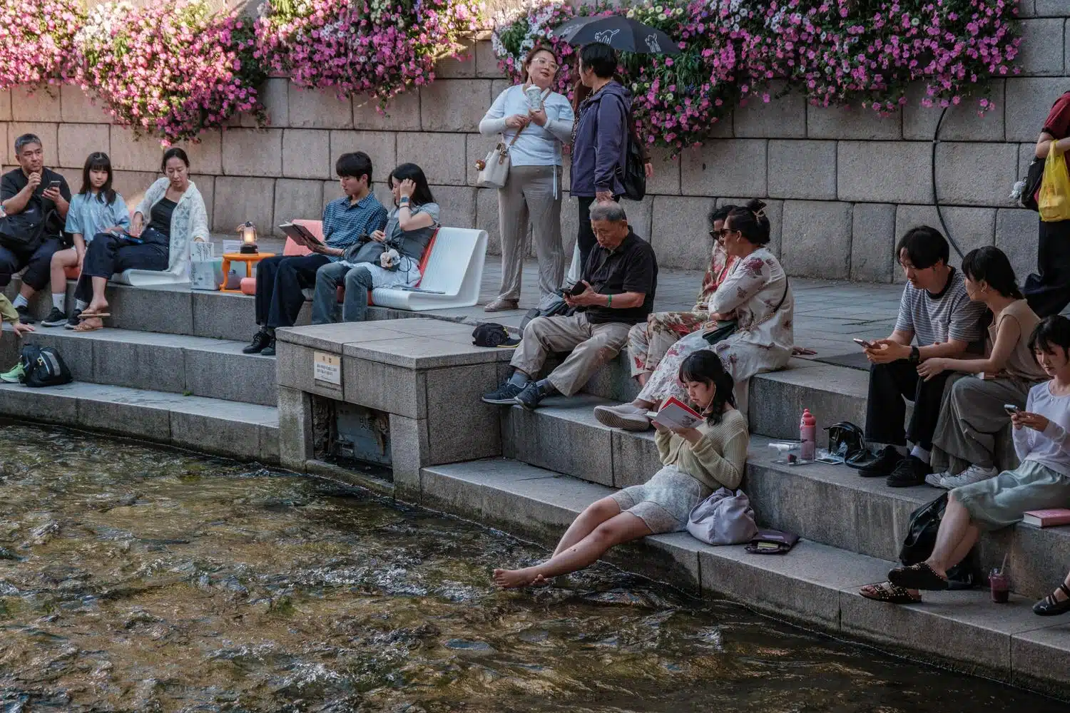 cheonggyecheon-stream-summer-water-feet People soak their feet in the water along Cheonggyecheon stream in Seoul.
