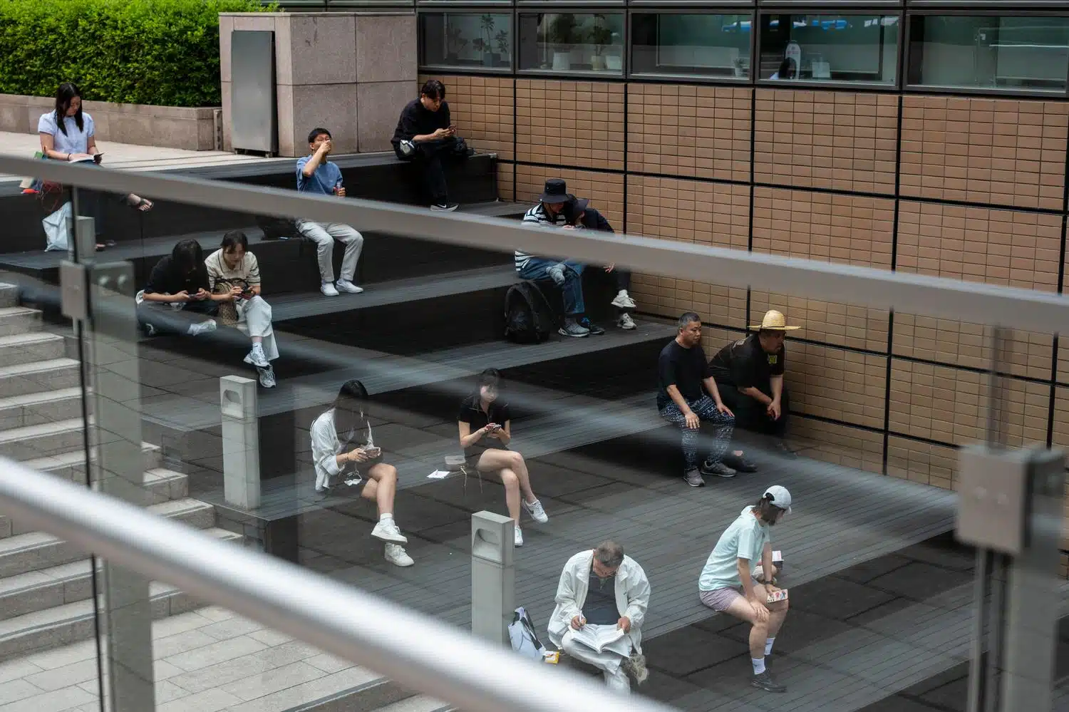kyobo-bookstore-seoul-stairs-summer-people People sit on stairs at the entrance of the Kyobo bookstore in Seoul.