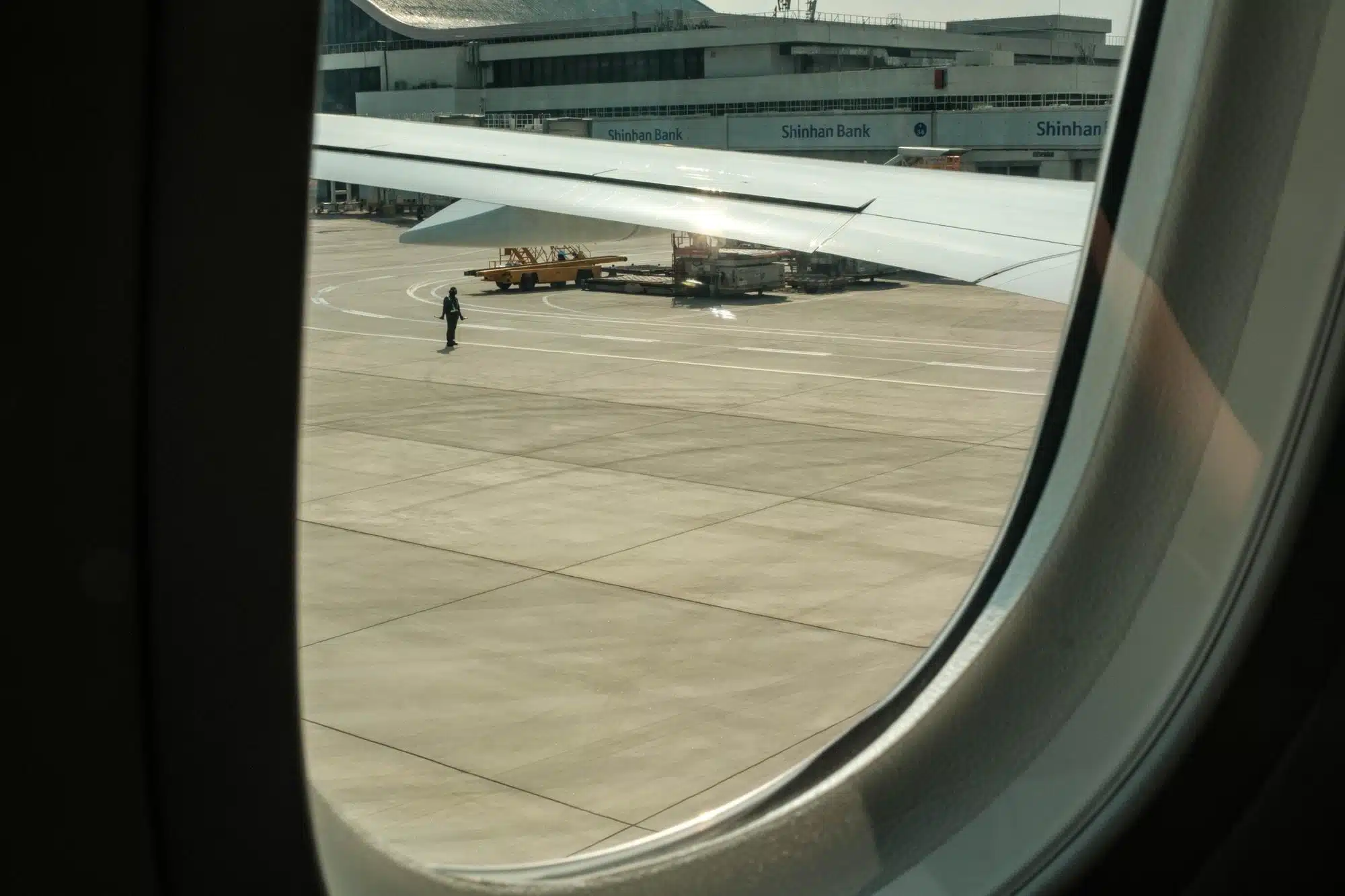 gimpo-airport-seoul-window-seat An airport employee is seen standing on the tarmac through a plane window at Seoul Gimpo airport.