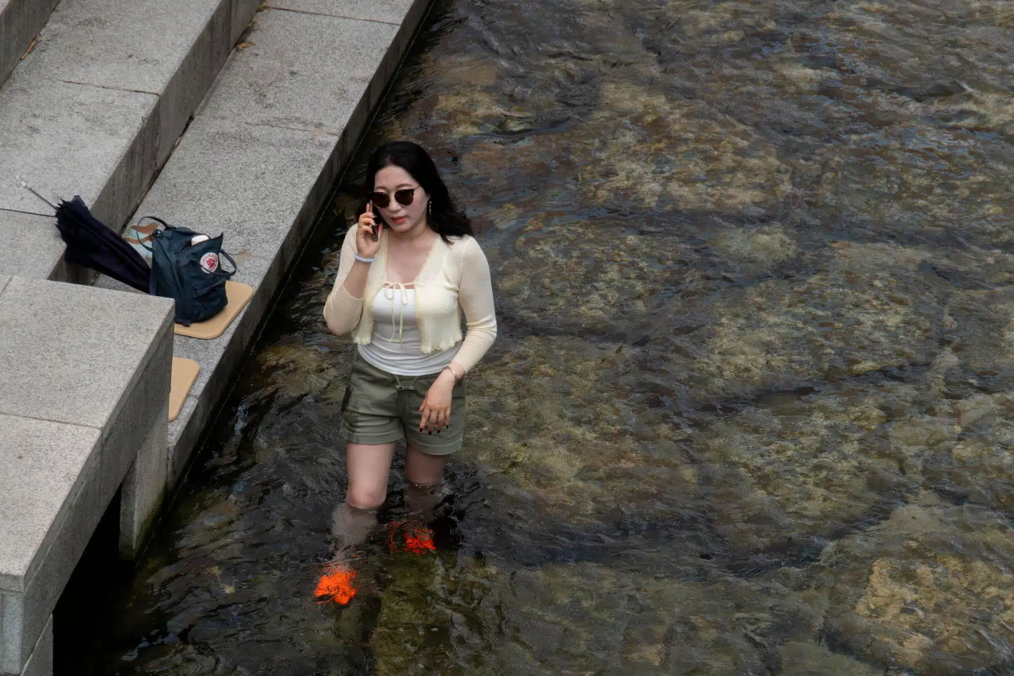 cheonggyecheon-stream-seoul-businesswoman A lady makes a phonecall while standing in the water at Cheonggyecheon stream in Seoul.